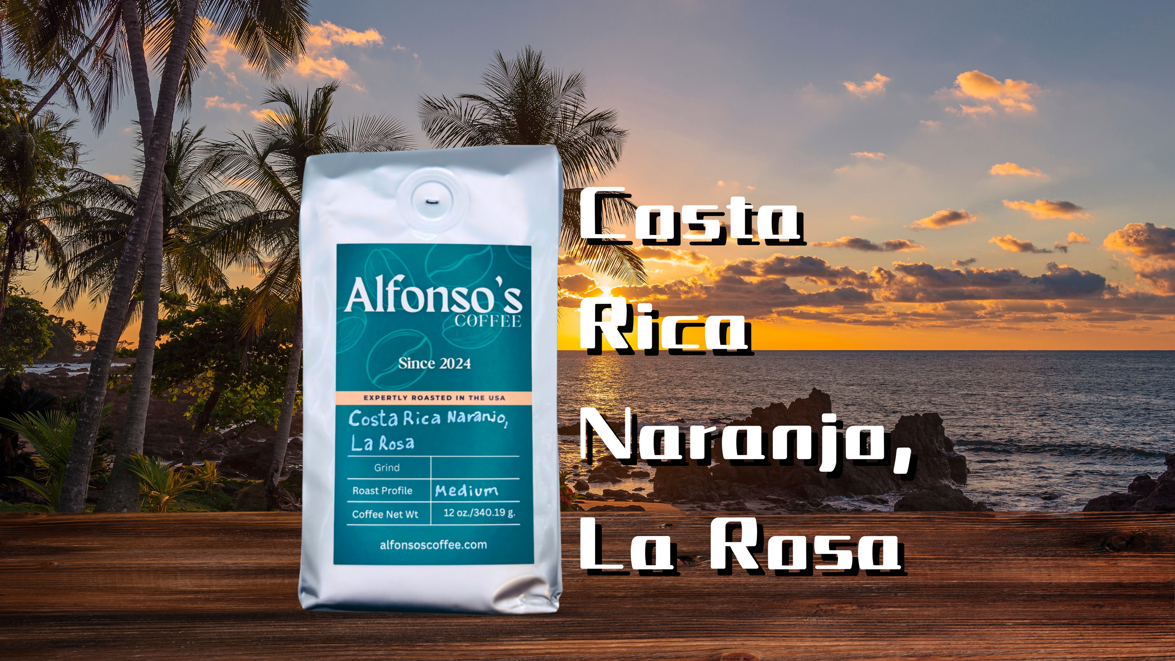 Product image featuring a bag of Alfonso’s Coffee Costa Rica Naranjo, La Rosa blend on a wooden table with a vibrant tropical sunset in the background. Palm trees frame the scenic view of the ocean and rocky shoreline, creating a warm and inviting atmosphere.